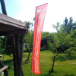 Beachflag Edge als Werbebanner in einem Garten