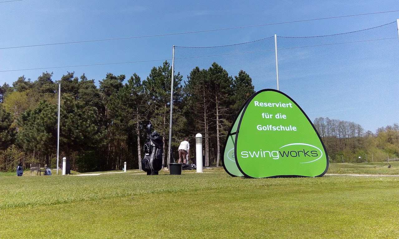 Pop Up Banner Triangle auf dem Golfplatz zum Reservieren von Bereichen für den Golfunterricht